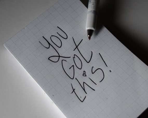 Inspirational handwritten note on graph paper with pen. Encouraging words 'You got this!'